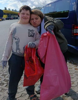 Schüler und Lehrerin mit Müllsack