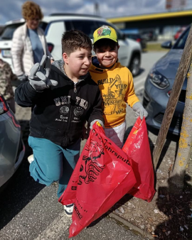 zwei Schüler mit Müllsäcken die für das Foto posen