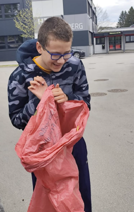 Ein Schüler mit einem Müllsack